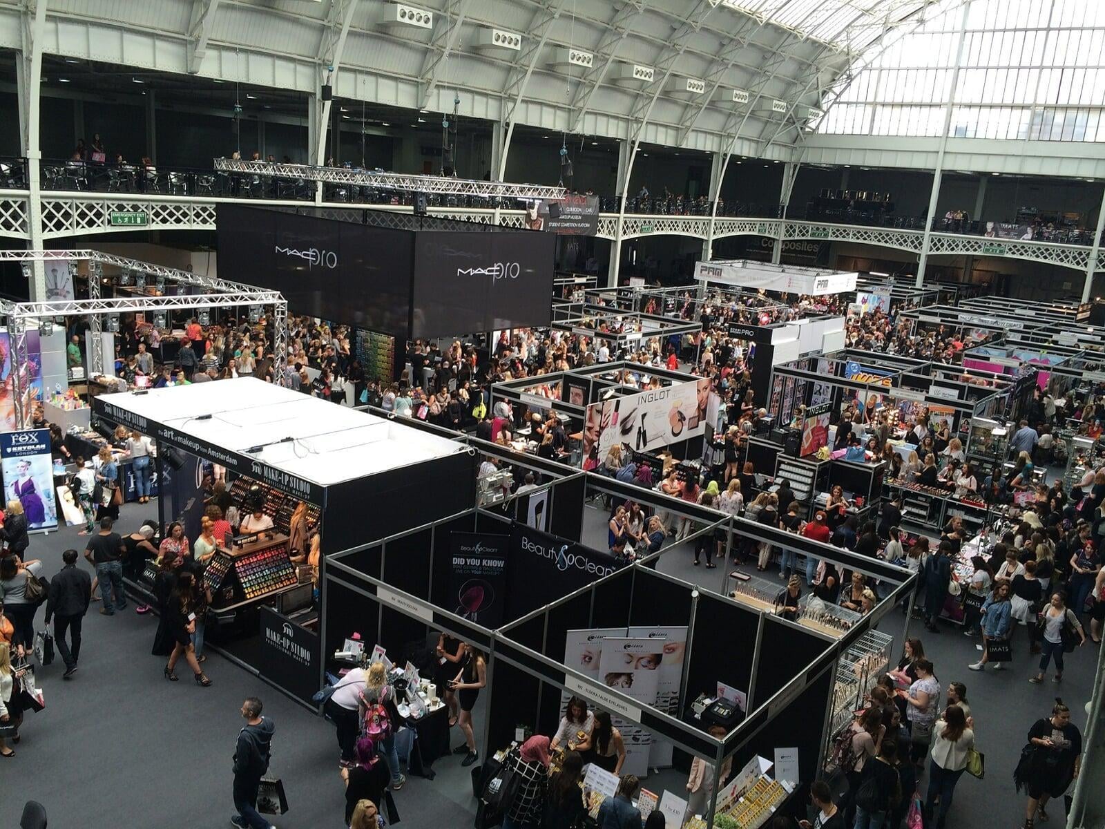 A large open and airy exhibition hall with multiple trade stands and busy attendees.